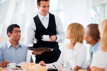 Server bringing coffee to table of guests