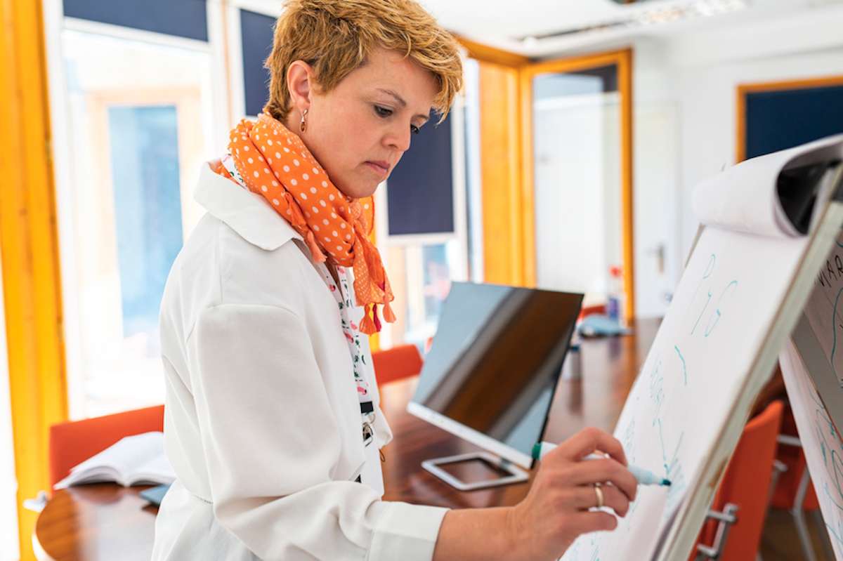 Businesswoman writes on a flip chart in modern office