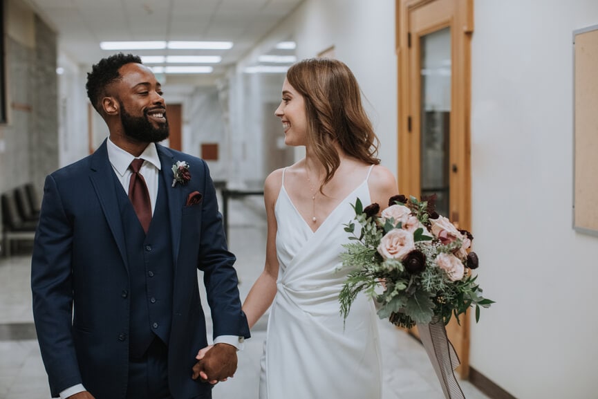 Newly married couple walking through the courthouse.