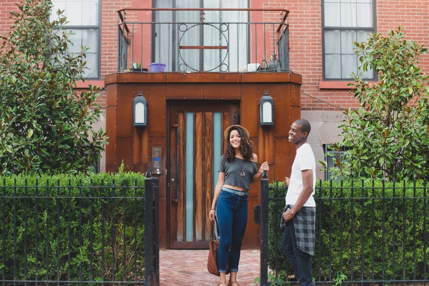 Young couple standing outside apartment