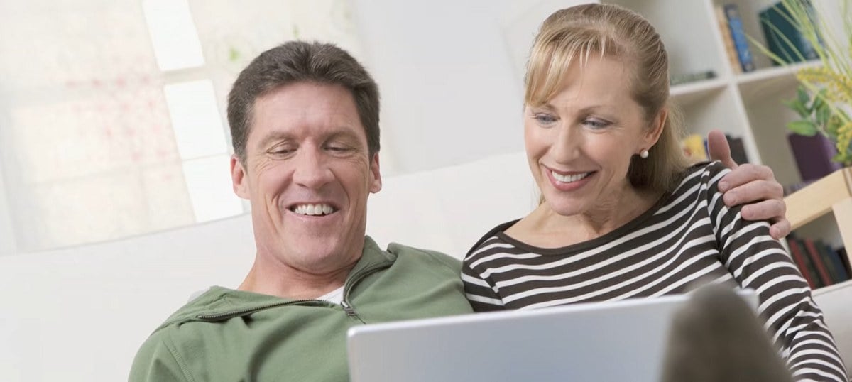 smiling couple looking at a laptop computer