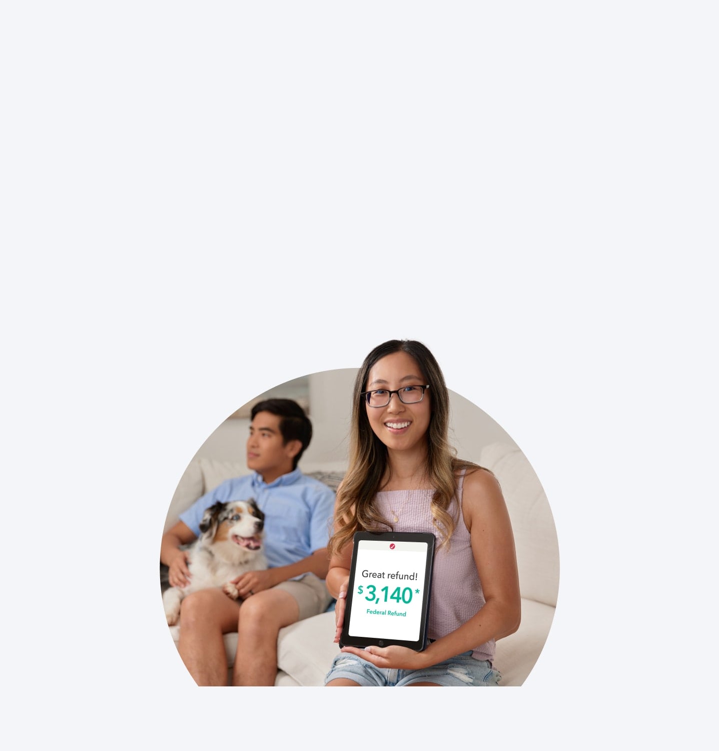 A TurboTax customer is smiling and sitting with her tablet.