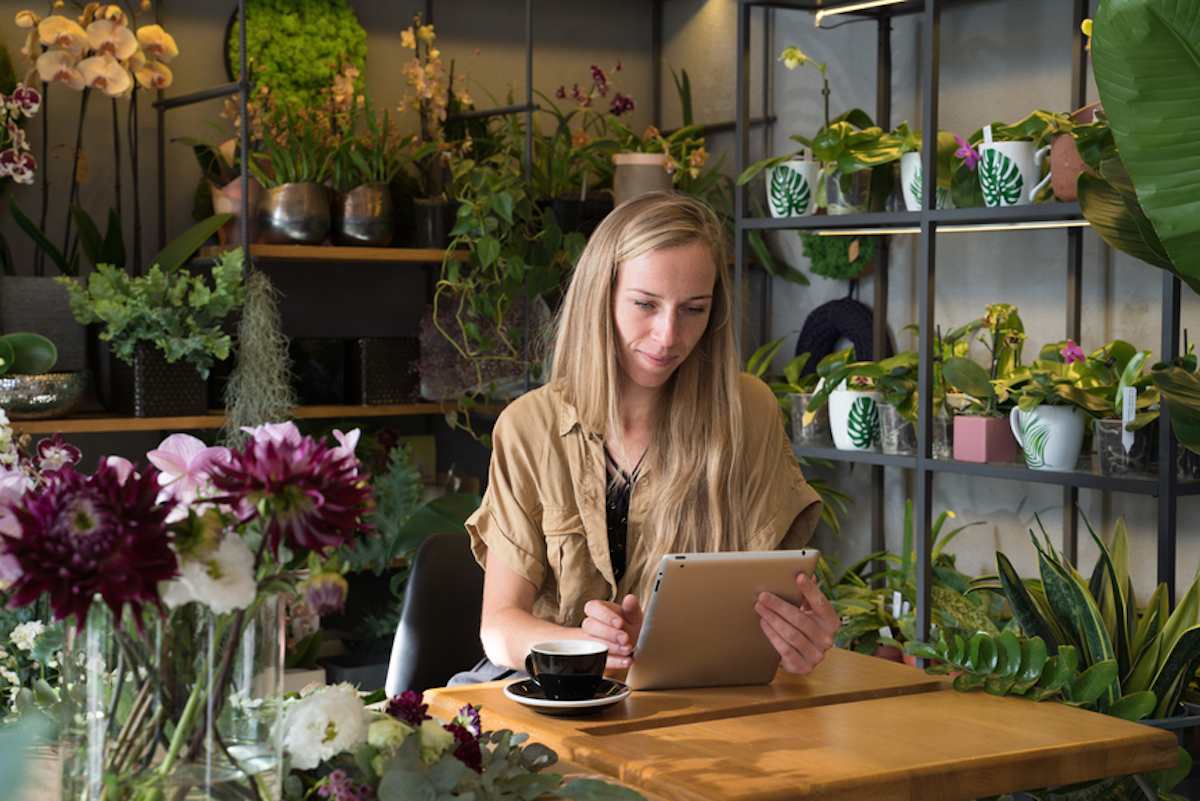 Female florist uses tablet in flower shop