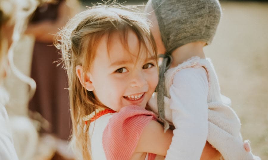 Happy girl smiling and holding a baby