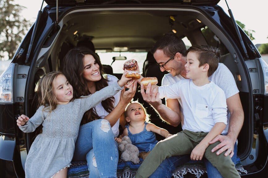 happy family eating donuts in car