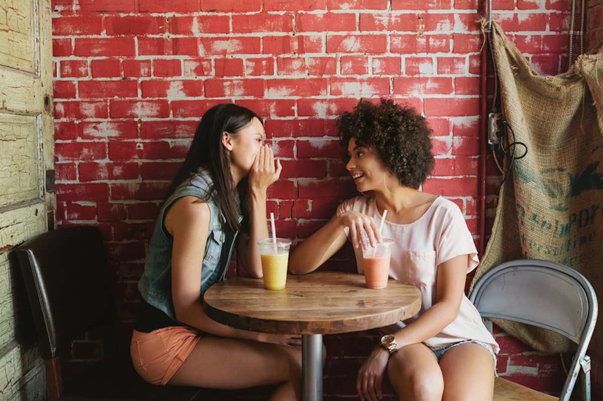 Two female friends talk at a coffee shop