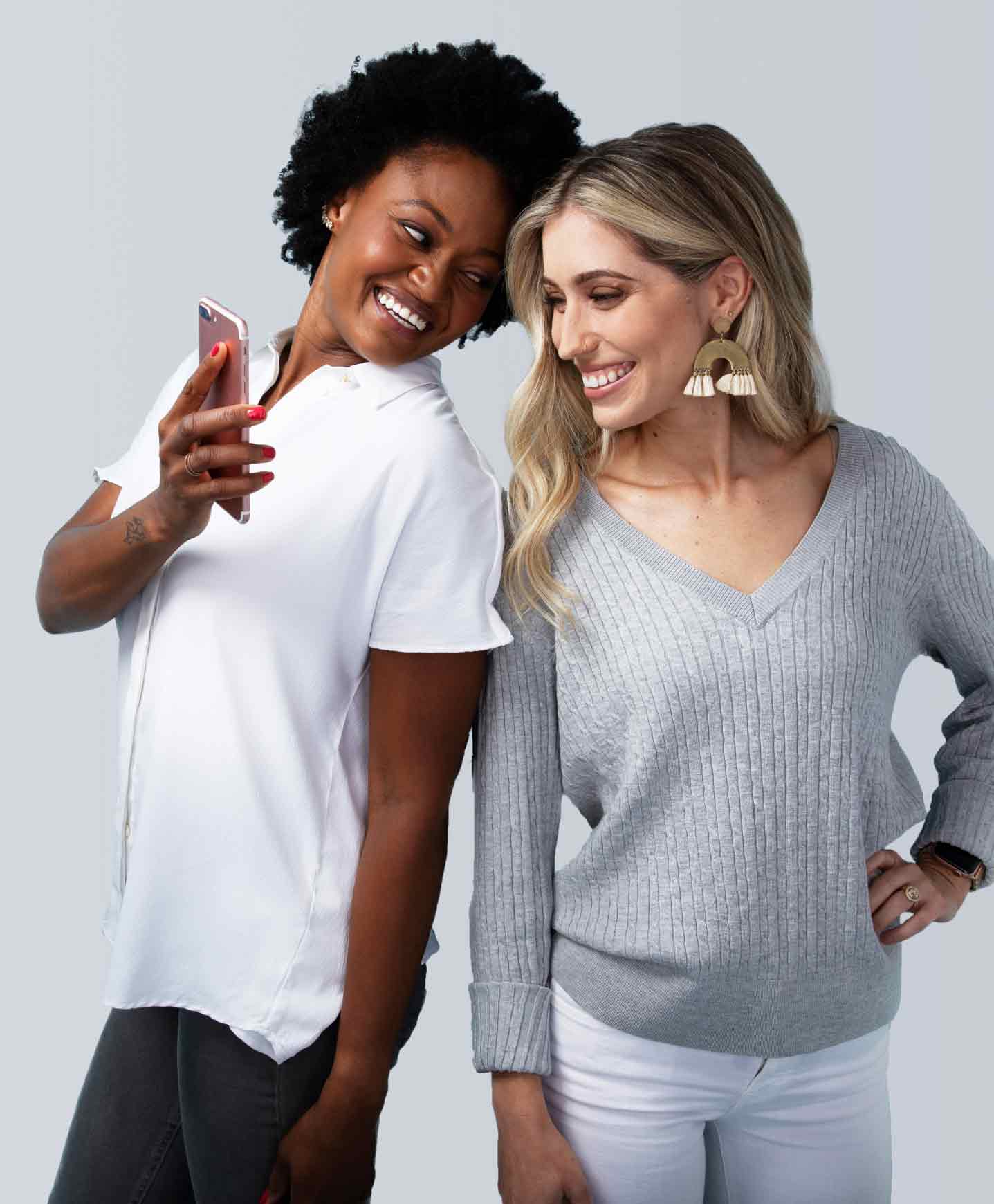 Two people looking at phone while smiling