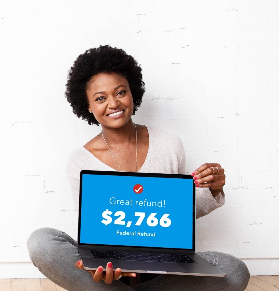 A woman is smiling and excited while looking at her federal refund she's getting with TurboTax's help.