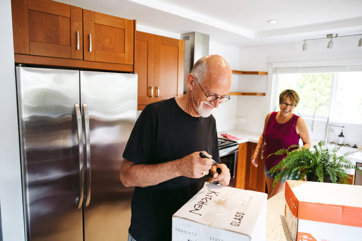 An older couple packs up their kitchen.
