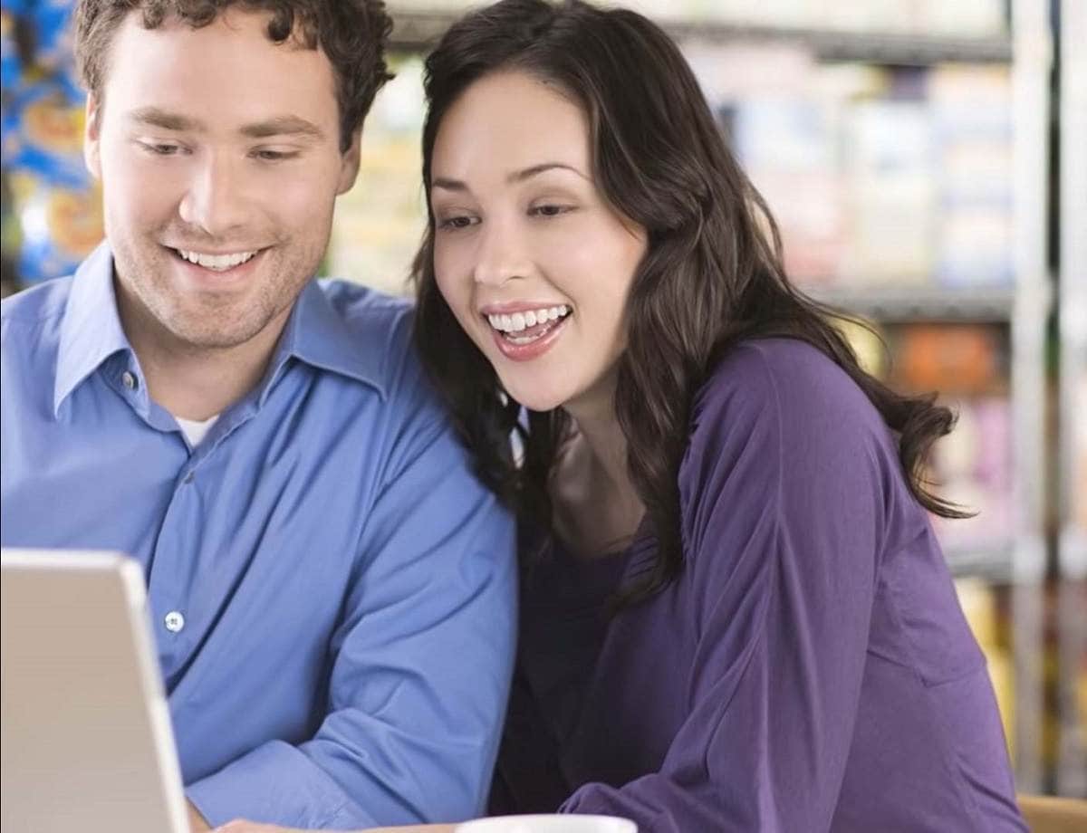 smiling couple looking at computer screen together