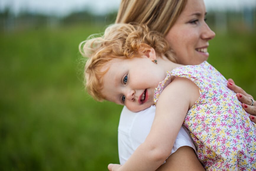 A woman holds a young child