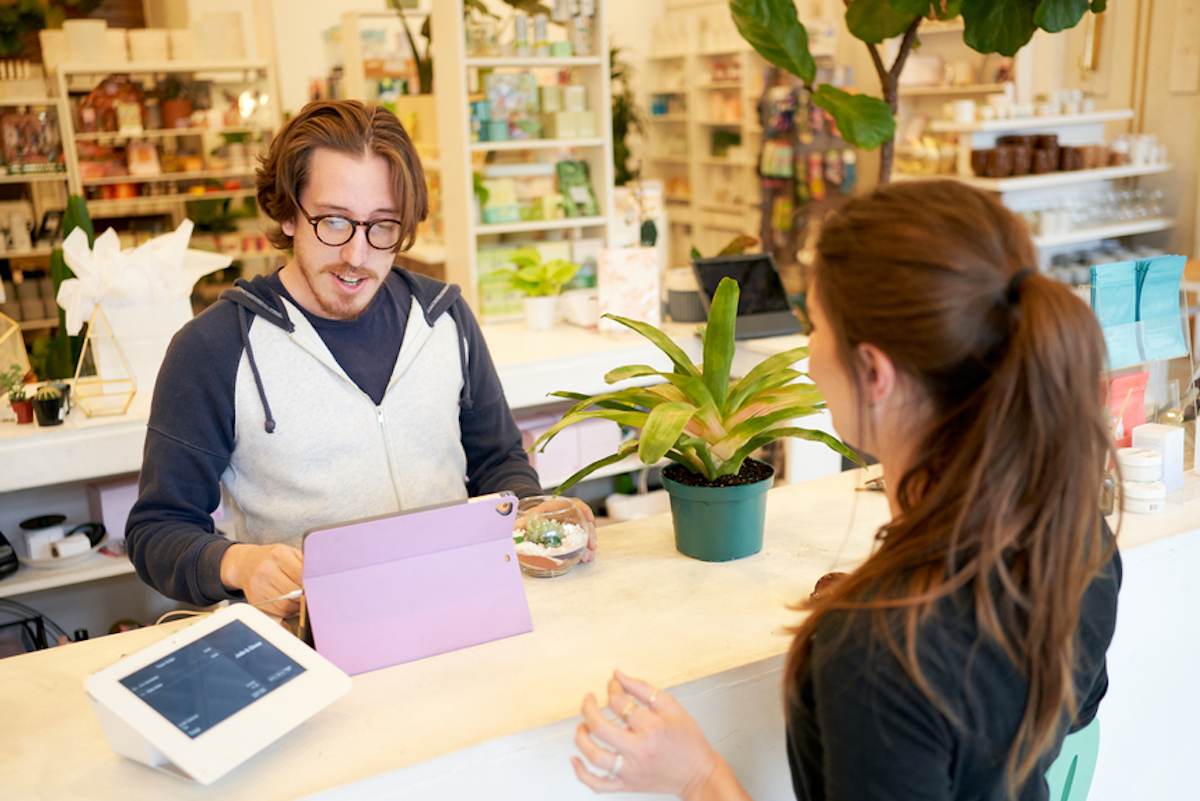 Woman with ponytail buys a plant in a mall