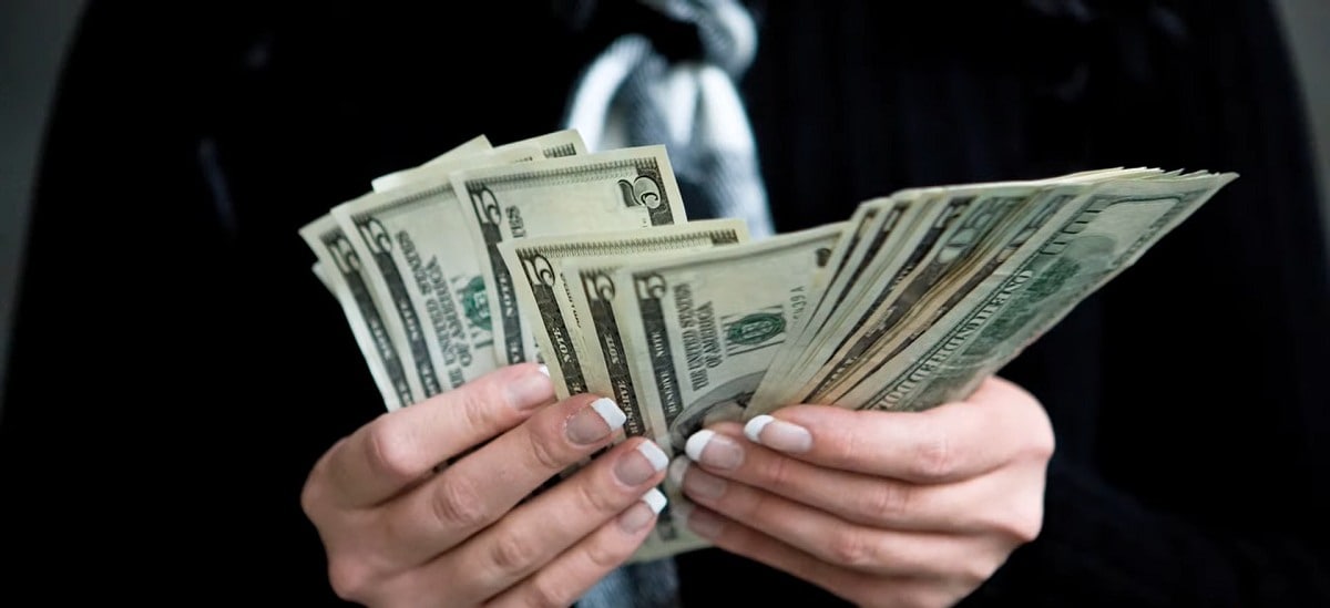 a woman holding cash in her hands