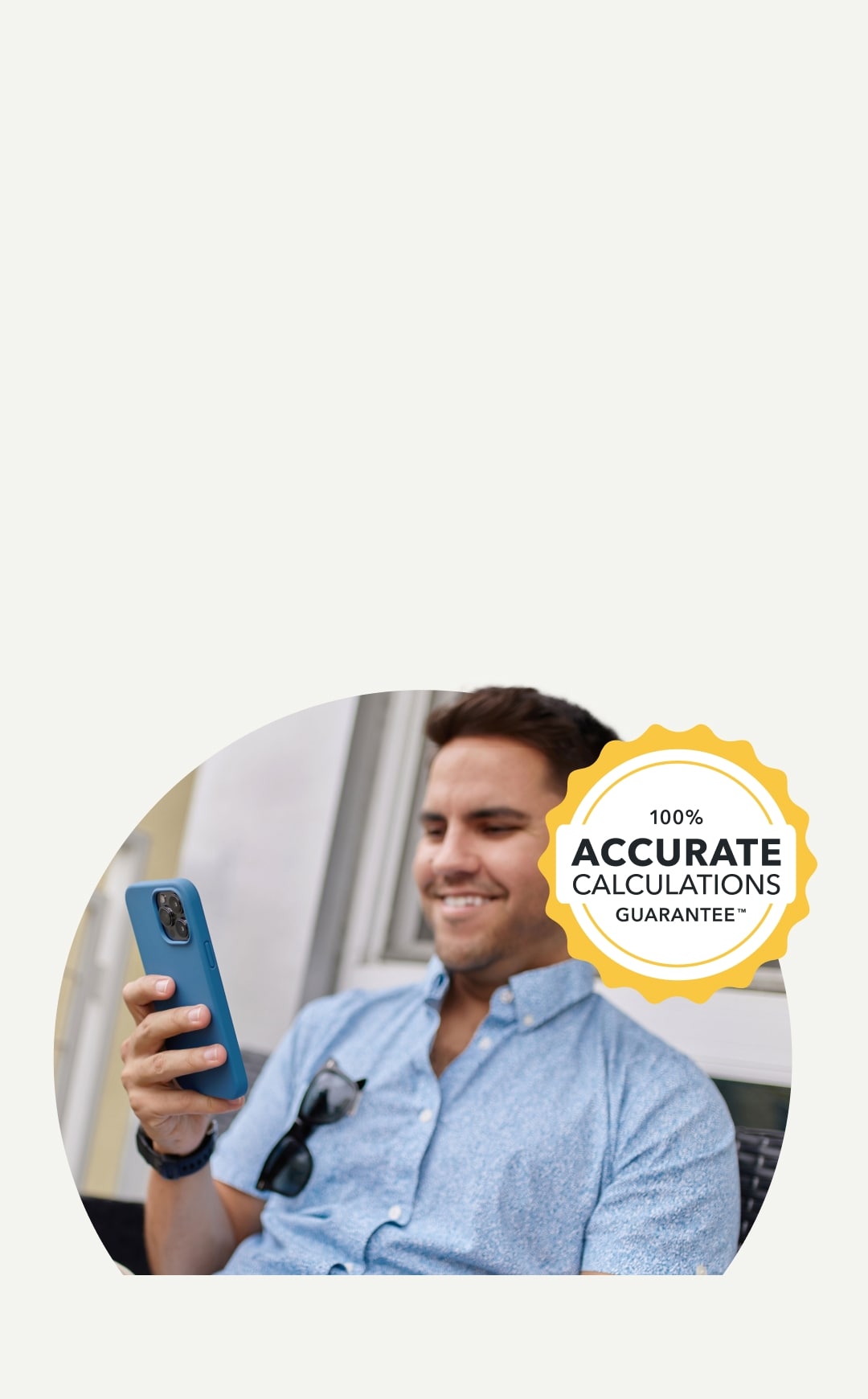 TurboTax customer is smiling as he looks down at his phone in his hands.
