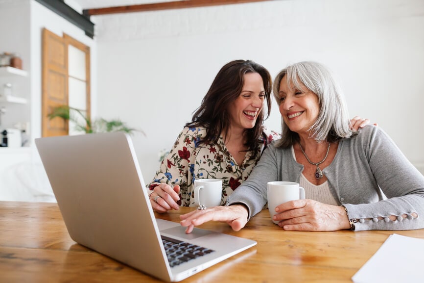 Mother and daughter having coffee and working together on their taxes.