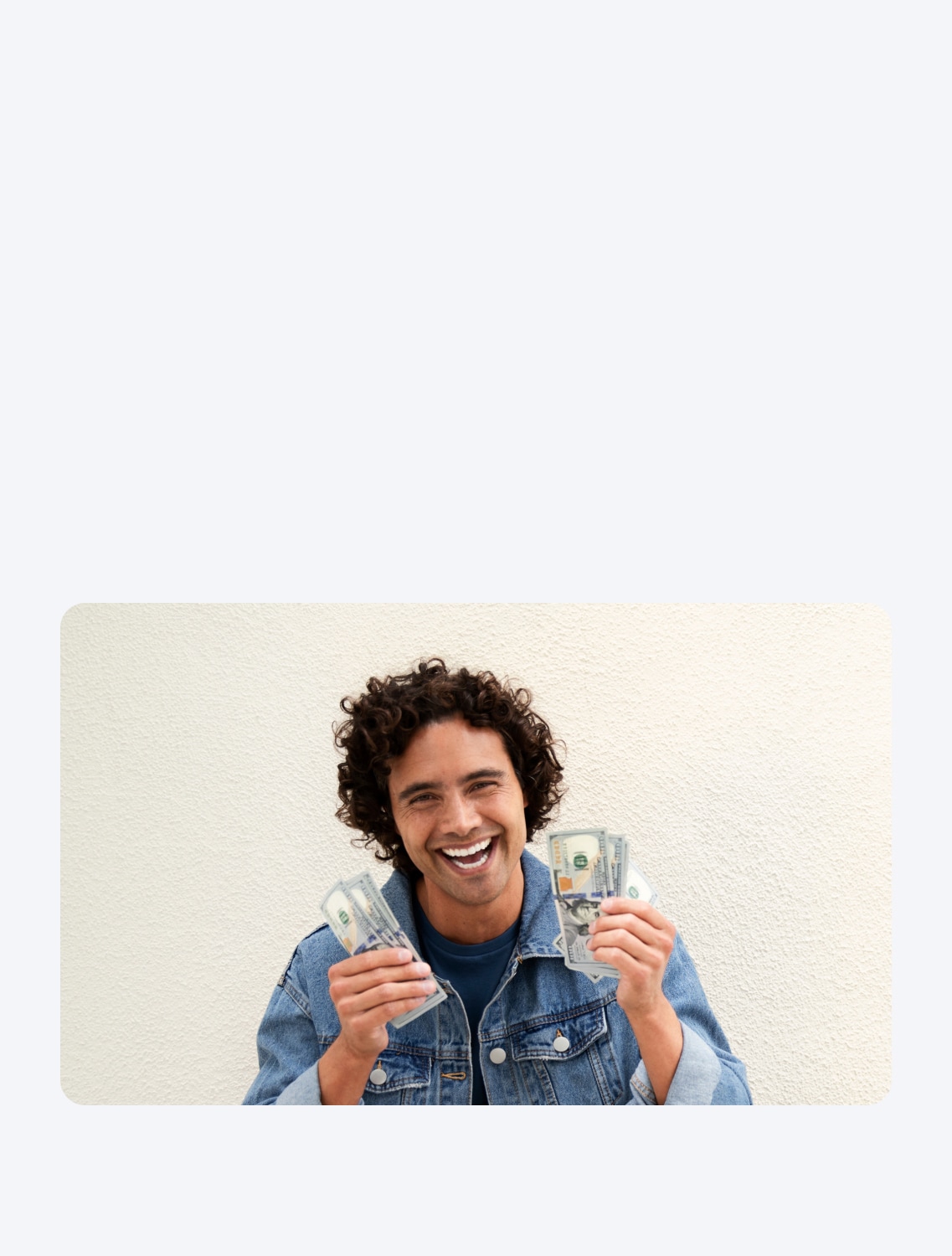 A TurboTax customer is grinning as he holds cash in both hands.