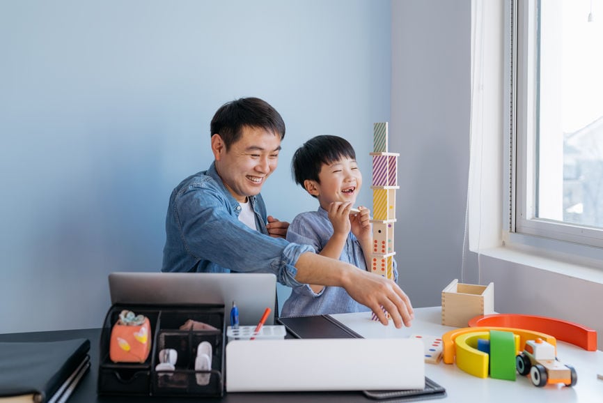 Father Working At Home While Son Plays