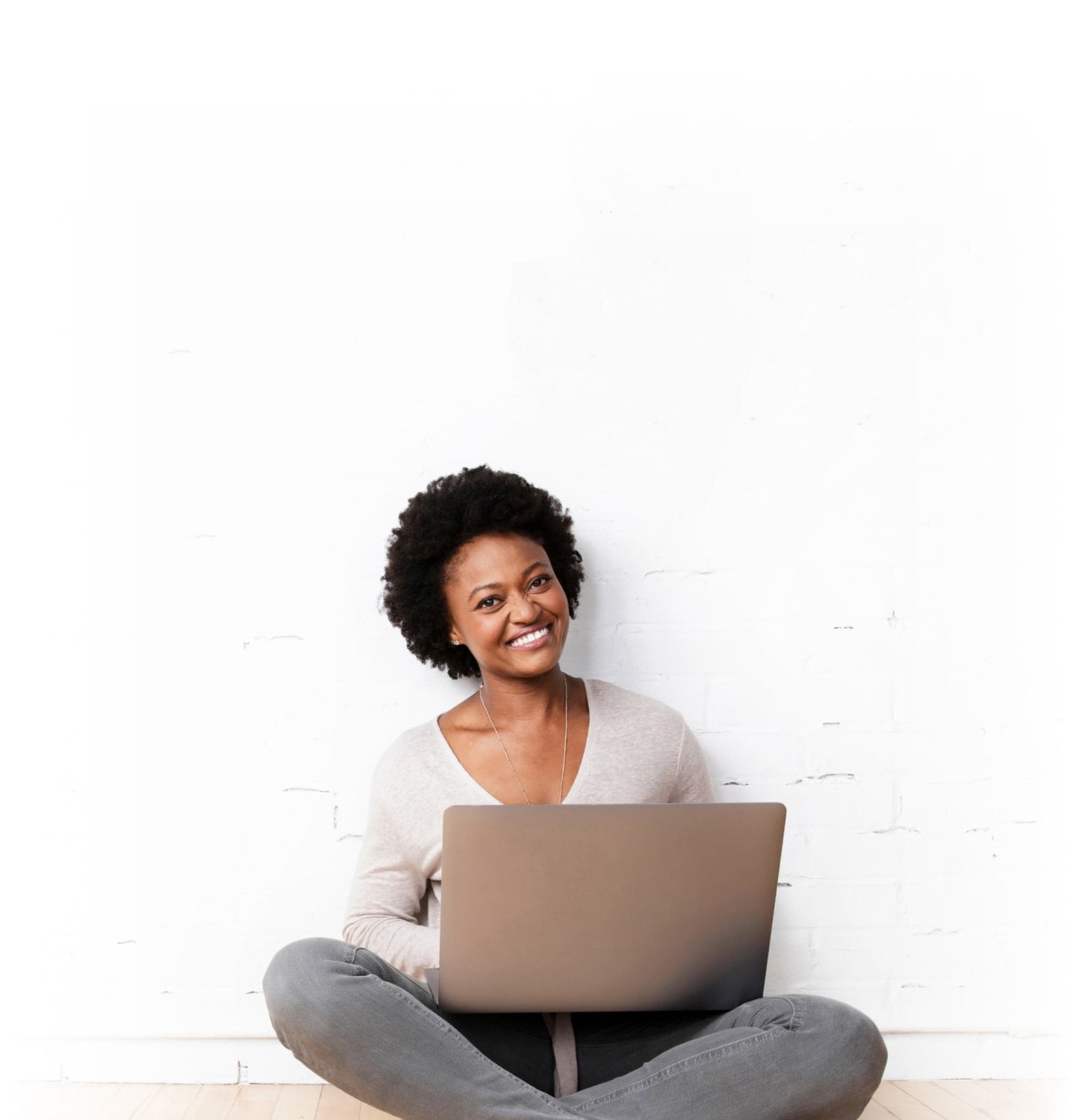 TurboTax customer Virginia is smiling as she holds her laptop open on her lap.