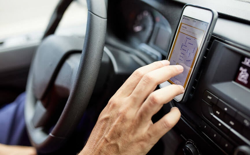 Close up of a driver using a delivery application in the car.