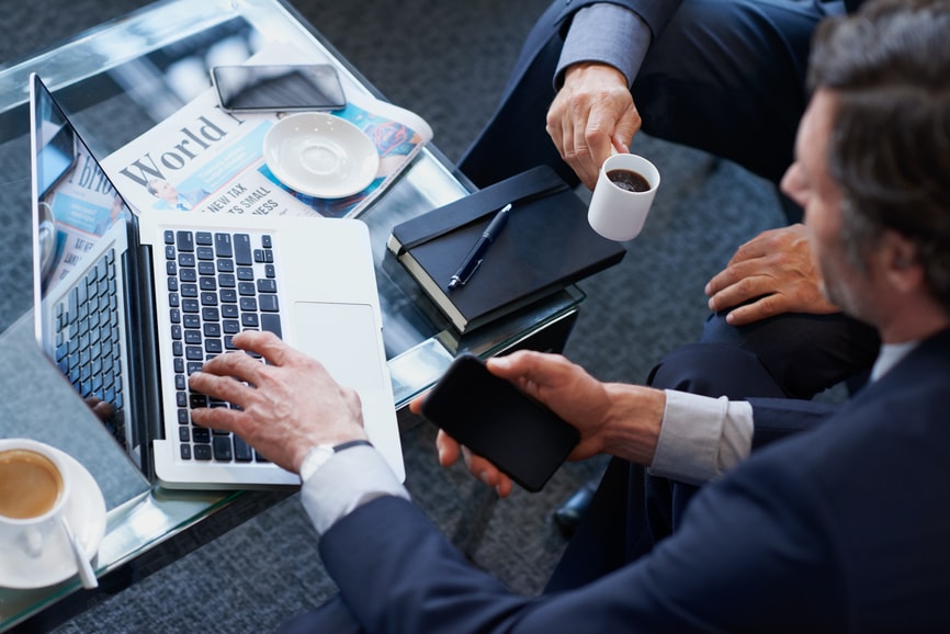 Businessmen drinking coffee at table