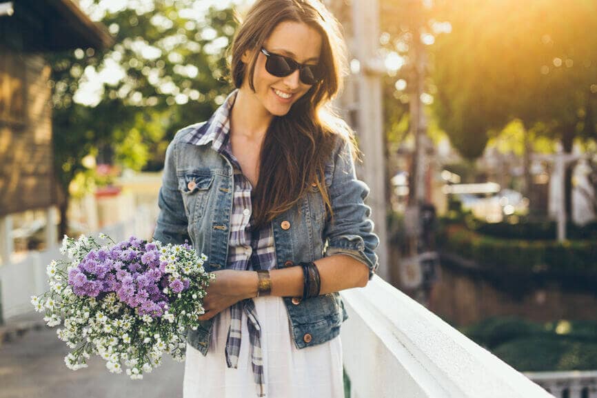 woman smiling and holding a bouquet of flowers