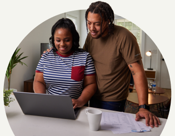 TurboTax customers Dev and Lamar working on their computer together at home. 