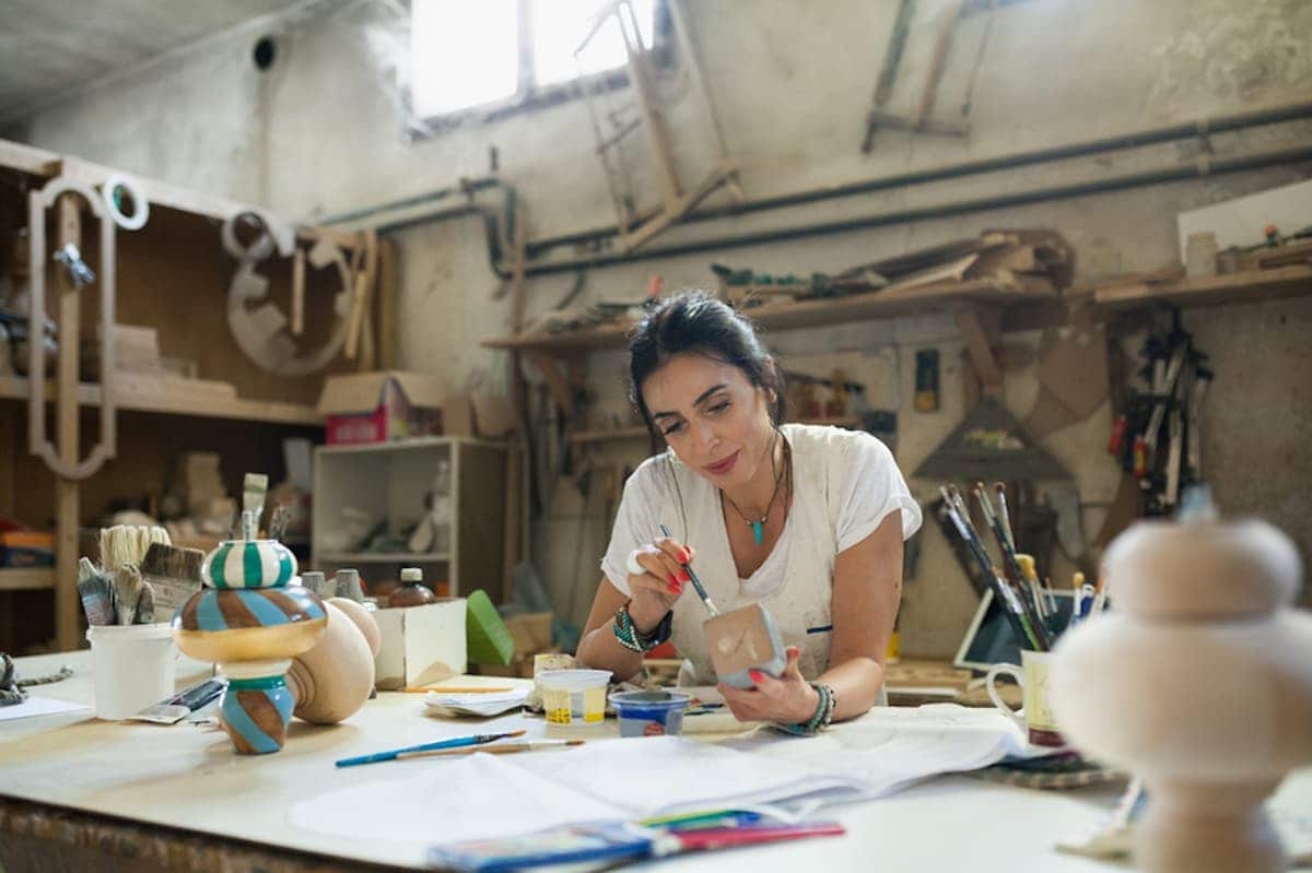 An artist works on pieces in her studio.