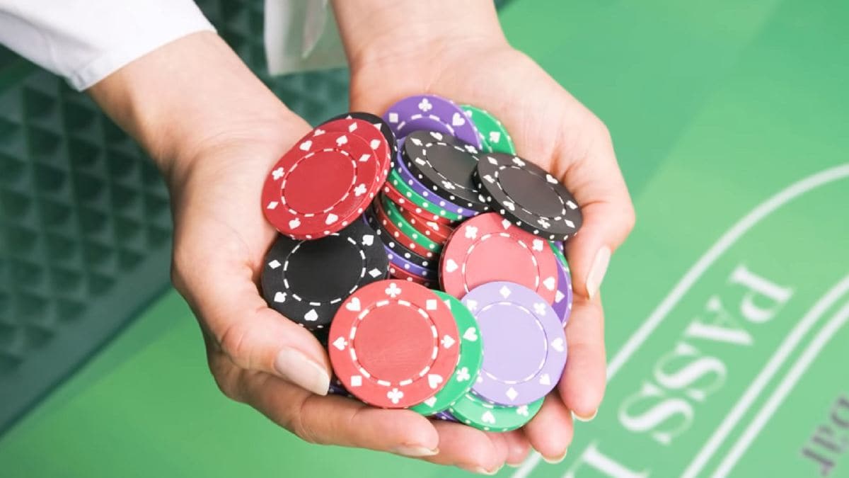 two hands holding casino gaming chips