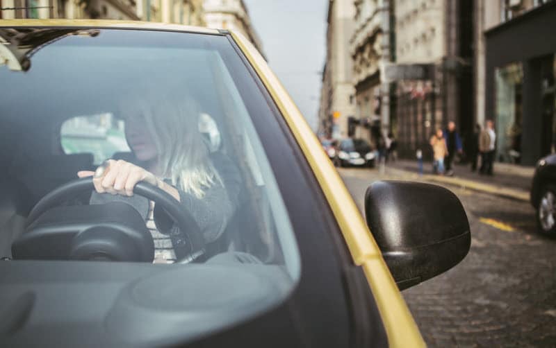 Woman driving a car in a busy city