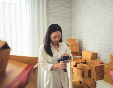 A person looking at a box of pizza.