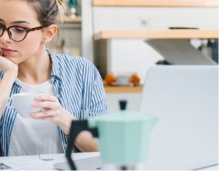 A person sitting at a table with a cup of coffee.