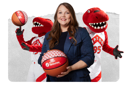 A female TurboTax expert smiling and holding a basketball with the “Intuit TurboTax” logo on it. A playful Toronto Raptors dino mascot on either side of her.