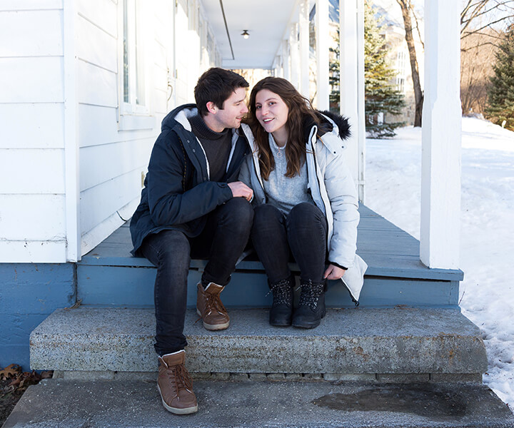 A person sitting on a couch using a laptop computer.