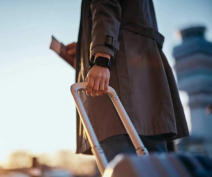 A person with a suit case pulling a suitcase.