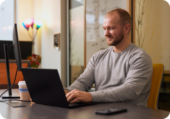 A man working at a laptop in their office space.