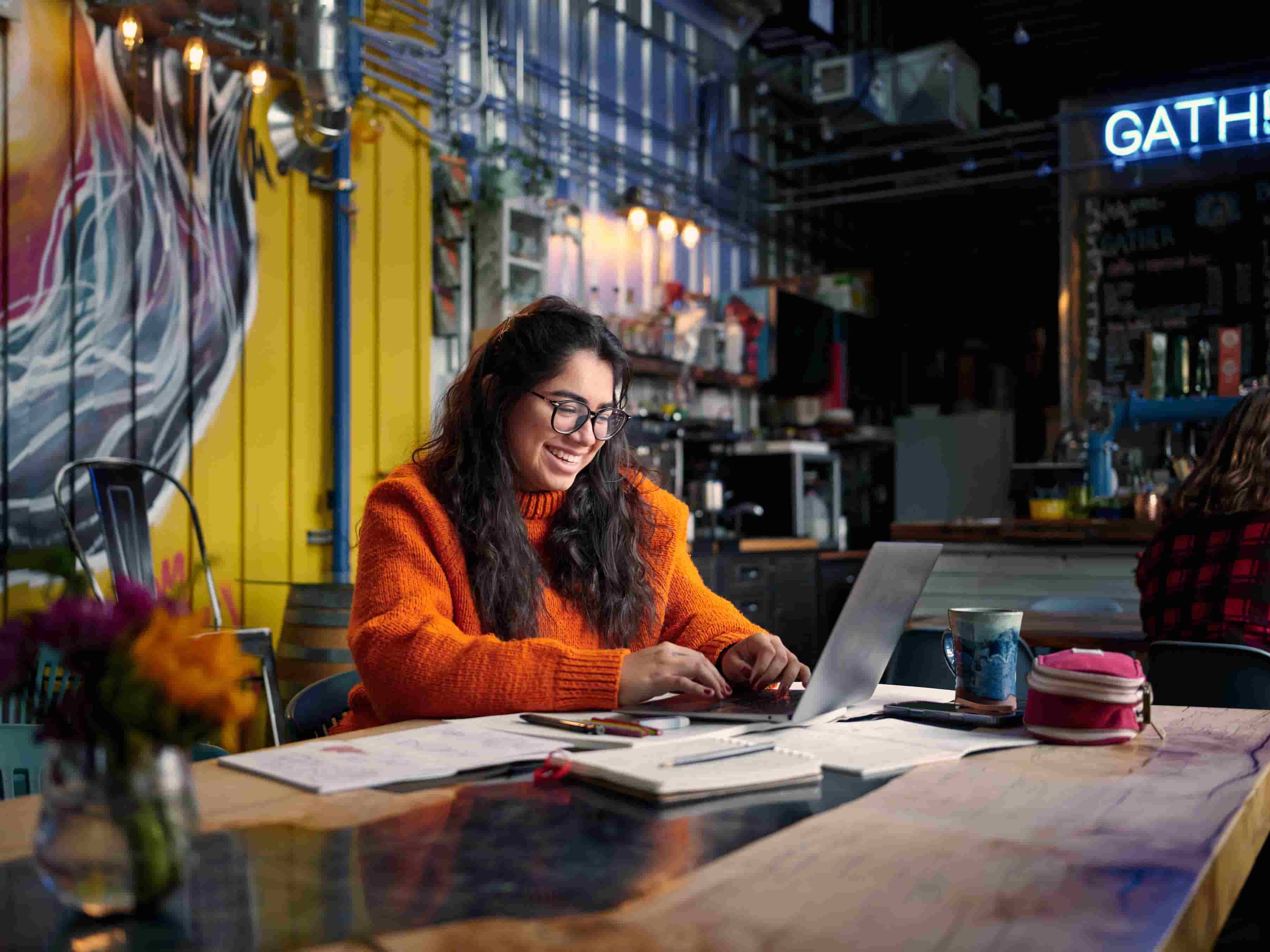 A person sitting at a table with a laptop.