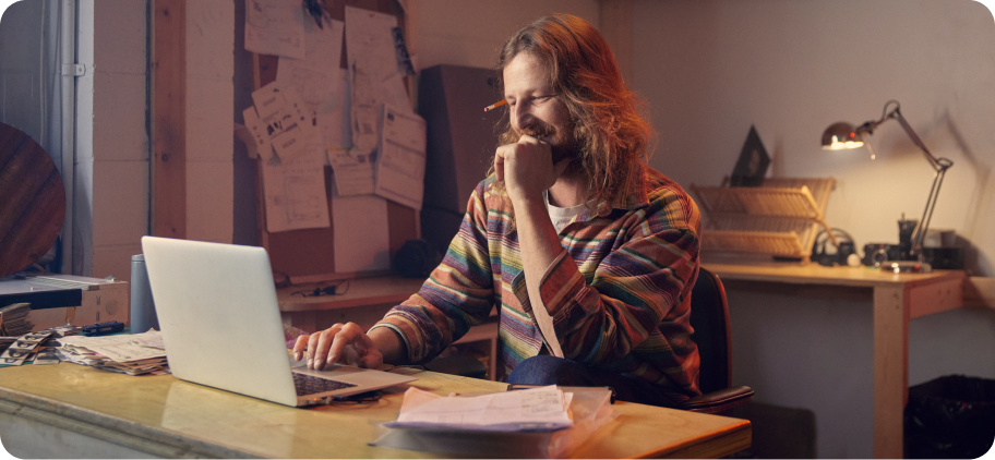 A man working on a laptop in his work studio.