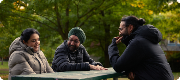 Trois personnes assises sur un banc dans les bois.