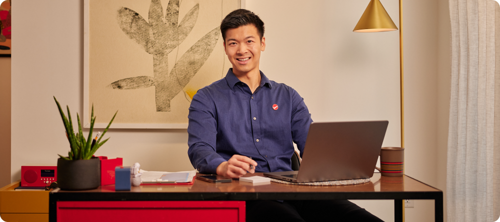 Une personne assise à une table avec un ordinateur portable.