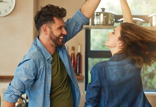 A person and person standing in a kitchen.