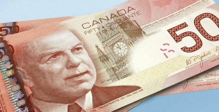 A picture of a Canadian money note with a Canadian flag on it.