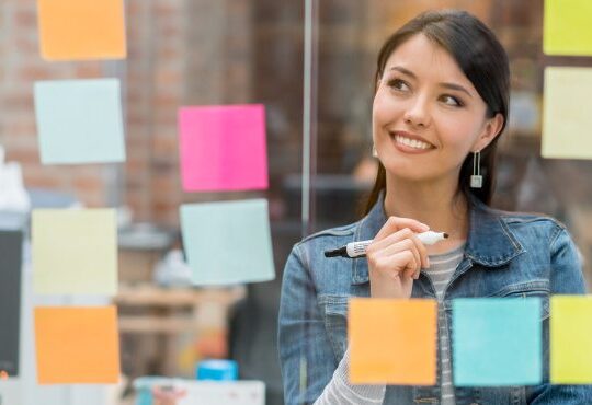 A person wiring on sticky notes with a marker.