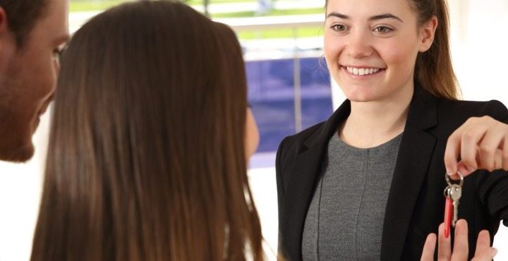 A person smiling and holding a piece of paper.