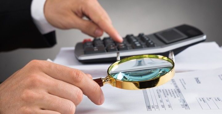 businessperson-checking-invoice-with-magnifying-glass-picture