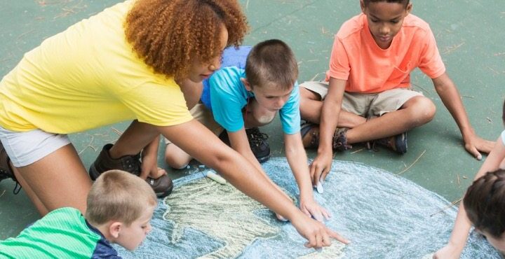 A group of children sitting on a ground.