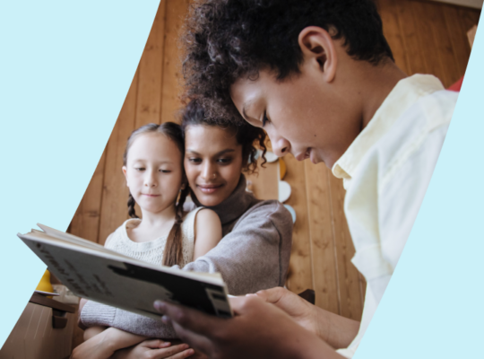 A person reading a book to two children.