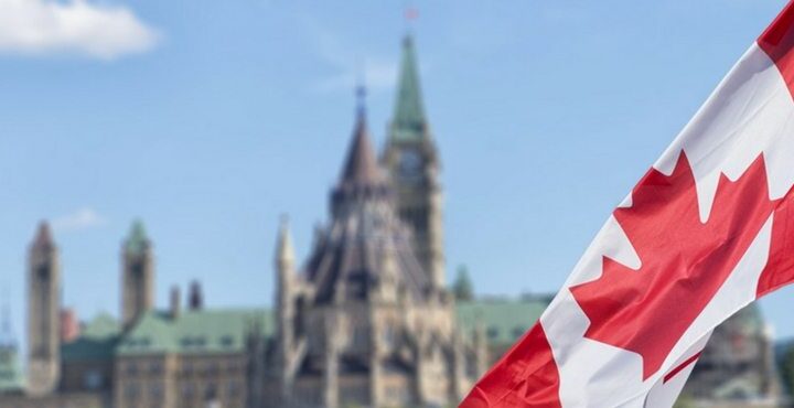 A Canadian flag flying in front of a Canadian castle.