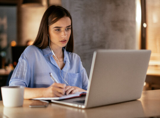 A person sitting at a table with a laptop.