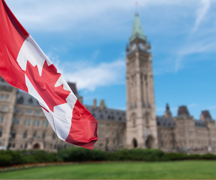 A Canadian flag flying in front of a Canadian flag.