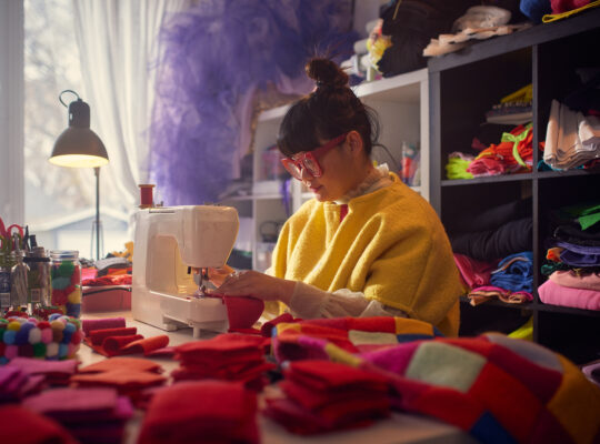 A person working in a sewing machine making shirts.